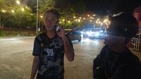 Wartawan Bola.com, Abdul Aziz, meminta warga Kamboja berbicara dengan sopir taksi online yang nyasar. (Bola.com/Abdul Aziz)