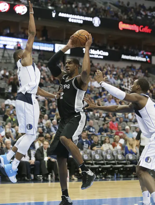 Pemain San Antonio Spurs, LaMarcus Aldridge (12) mencoba melewati adangan dua pemain Dallas Mavericks pada laga NBA Basketball game di American Airlines Center, Dallas, (14/11/2017). Spurs menang 97-91. (AP/LM Otero)
