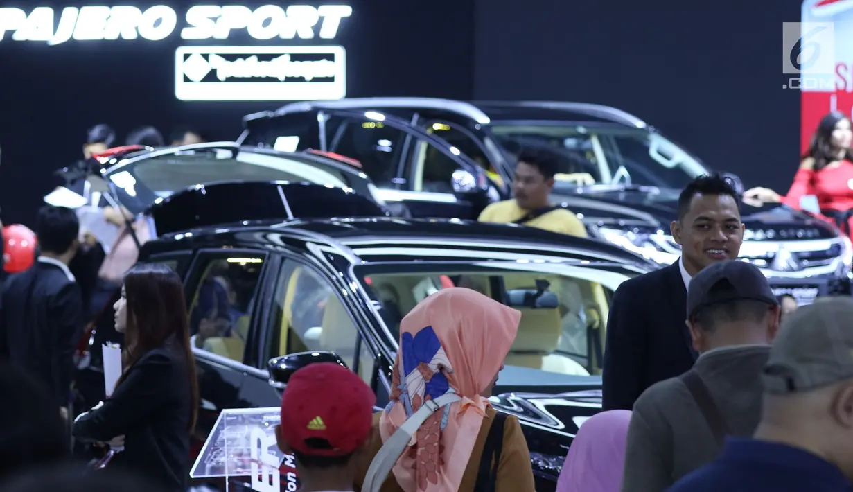 Pengunjung mengecek kondisi mobil yang dipamerkan pada Indonesia International Motor Show 2018 di JIExpo, Jakarta, Minggu (29/4). Hingga Jumat (27/4), IIMS 2018 telah mencatatkan angka kunjungan 408.352 orang. (Liputan6.com/Helmi Fithriansyah)