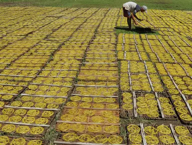 Pekerja menjemur kerupuk mie kuning yang merupakan salah satu makanan khas berbuka puasa di Karadenan, Bogor (22/05). Kerupuk mie kuning ini biasanya disajikan dengan sambal kacang dan pecel sayur. (Merdeka.com/Arie Basuki)