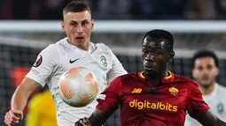 Gelandang Ludogorets, Jakub Piotrowsky berebut bola dengan gelandang AS Roma Mady Camara pada Matchday 6 Grup C Liga Eropa 2022-2023 di Olimpico, Jumat (4/10/2022) dini hari WIB. Sedangkan Lorenzo menempati peringkat tiga dengan poin 7. (Alberto PIZZOLI / AFP)