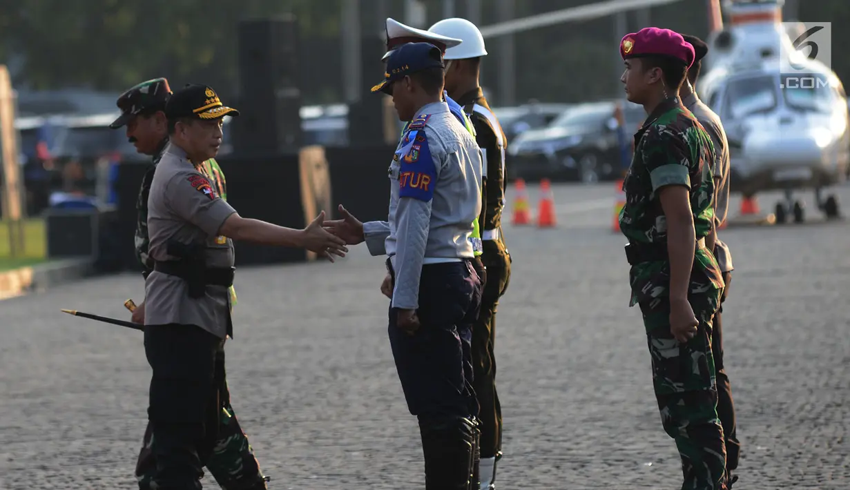 Kapolri Jenderal Pol Tito Karnavian bersalaman dengan petugas Dishub saat gelar apel operasi ketupat 2019 di lapangan Silang Monas, Jakarta, Selasa (28/5/2019). Apel gelar pasukan operasi ketupat 2019 melibatkan  160.335 personel gabungan. (merdeka.com/Imam Buhori)