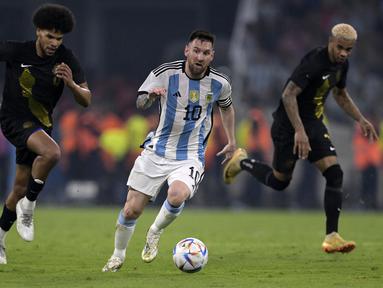 Pemain Timnas Argentina, Lionel Messi menggiring bola melewati pemain Curacao pada laga uji coba internasional yang berlangsung di Stadion Unico Madre de Ciudades, Rabu (29/3/2023) pagi WIB. La Pulga berhasil mencetak hattrick dan membawa timnya menang dengan skor 7-0. (AFP/Juan Mabromata)