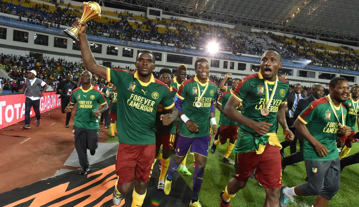 Bek Kamerun, Michael Ngadeu-Ngadjui mengangkat piala saat merayakan kemenangan atas Mesir pada laga final Piala Afrika 2017 di Stade de I'Amitie, Gabon, Minggu (5/2). Kamerun meraih gelar kelima Piala Afrika usai menang 2-1 atas Mesir. (ISSOUF SANOGO/AFP)