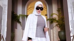 Tampil dalam hijab berwarna putih sesuai dengan busana yang digunakan, penampilan Syahrini satu ini terlihat memesona. Dirinya pun tak menggunakan aksesoris berlebih dan hanya mempercantik penampilan menggunakan kacamata hitam. (Liputan6.com/IG/@princessyahrini)