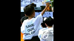 Seorang bocah asyik bermain dengan pesawat kayu di acara "Save Our Children", Jakarta, Minggu (23/11/2014) (Liputan6.com/Faisal R Syam)