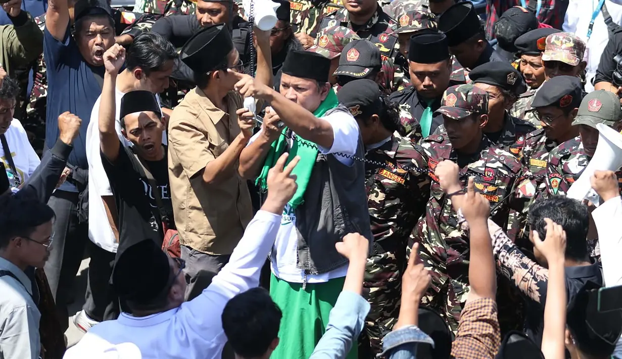 Simpatisan calon Ketua Umum PBNU KH Muhammad Yusuf Chudlori atau Gus Yusuf menggelar aksi demonstrasi di pintu akses Sidang Pleno IV Muktamar ke-35 Nahdlatul Ulama (NU) di Gedung Serba Guna, Pondok Pesantren Bahrul Ulum, Jombang, Jawa Timur, Minggu, 30 Agutus 2026. (Liputan6.com/ Ahmad Apriyono)