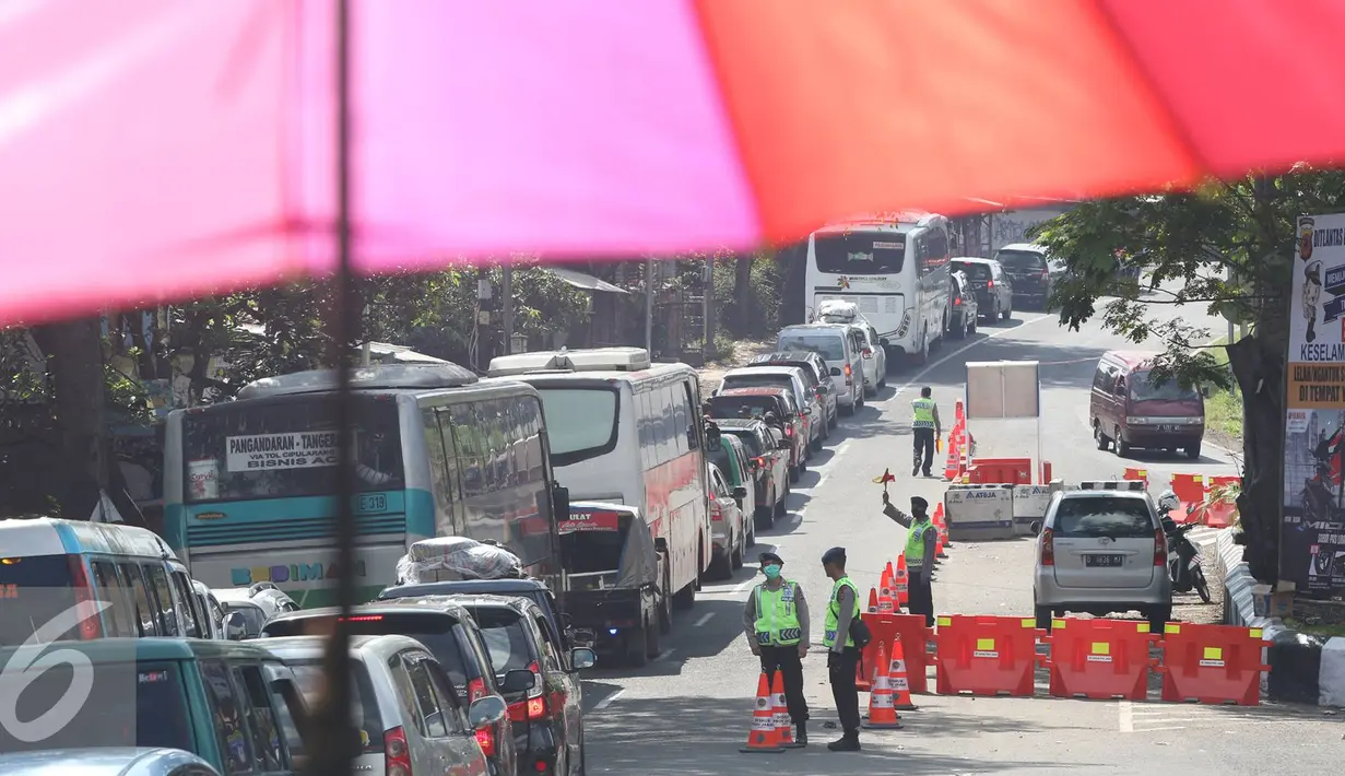 Petugas mengatur lalu lintas di sepanjang Simpang Cagak Nagreg, Jawa Barat, Minggu (3/7).H-3 menjelang lebaran volume kendaraan yang melintas meningkat ditambah dengan aktivitas pasar yang ada di kawasan tersebut. (Liputan6.com/Immanuel Antonius)