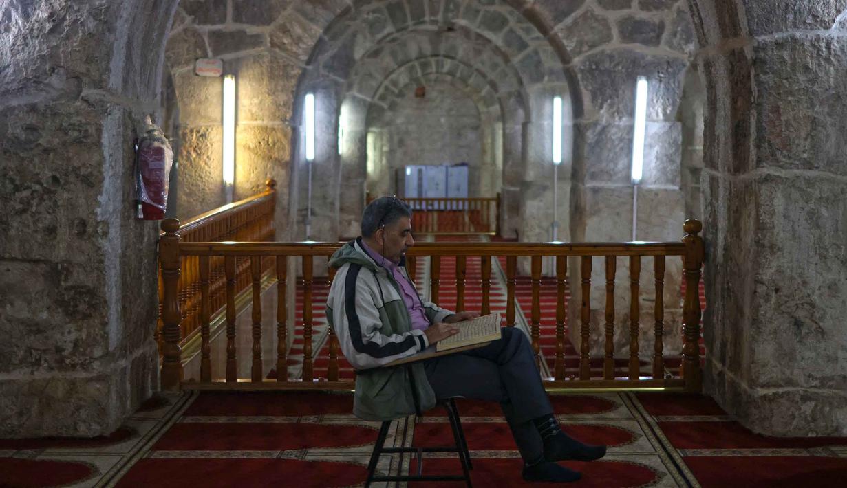 Setiap Ramadan tiba, Kubah Batu di kompleks Masjid al-Aqsa ramai dikunjungi umat Muslim untuk menghabiskan waktu dengan membaca Al-Quran. Tampak dalam foto, seorang pria Palestina membaca Al-Quran di dalam masjid al-Marawani yang terletak di kompleks Masjid al-Aqsa, Yerusalem menjelang waktu berbuka puasa selama bulan suci Ramadan 1447 Hijriah pada Rabu 25 Februari 2026. (AHMAD GHARABLI/AFP)
