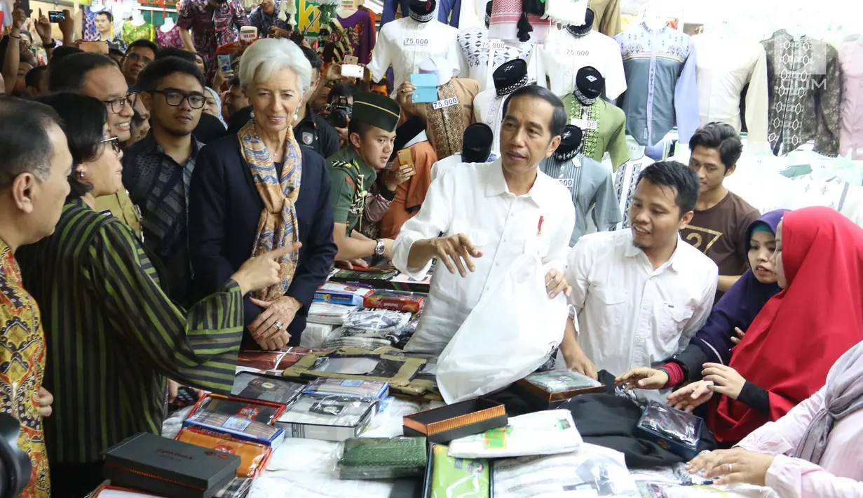 Presiden Jokowi menemani Direktur Pelaksana IMF Christine Lagarde memilih baju koko di salah satu toko Blok A Pasar Tanah Abang, Jakarta, Senin (26/2). Di toko itu Jokowi membantu menanyakan harga dan baju-baju yang ada. (Liputan6.com/Angga Yuniar)