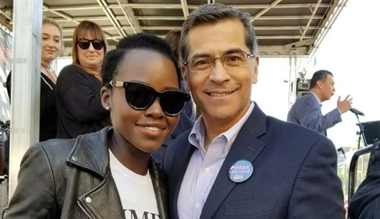 Lupita Nyong'O mengenakan kaos hitam bertuliskan "Time's Up". Ia memadukan kaos tersebut dengan blazer kulit. Dalam sebuah foto, Lupita Nyong'O berpose bersama Xavier Becerra yang merupakan kepala House Democratic Caucus (instagram/lupitanyongo)