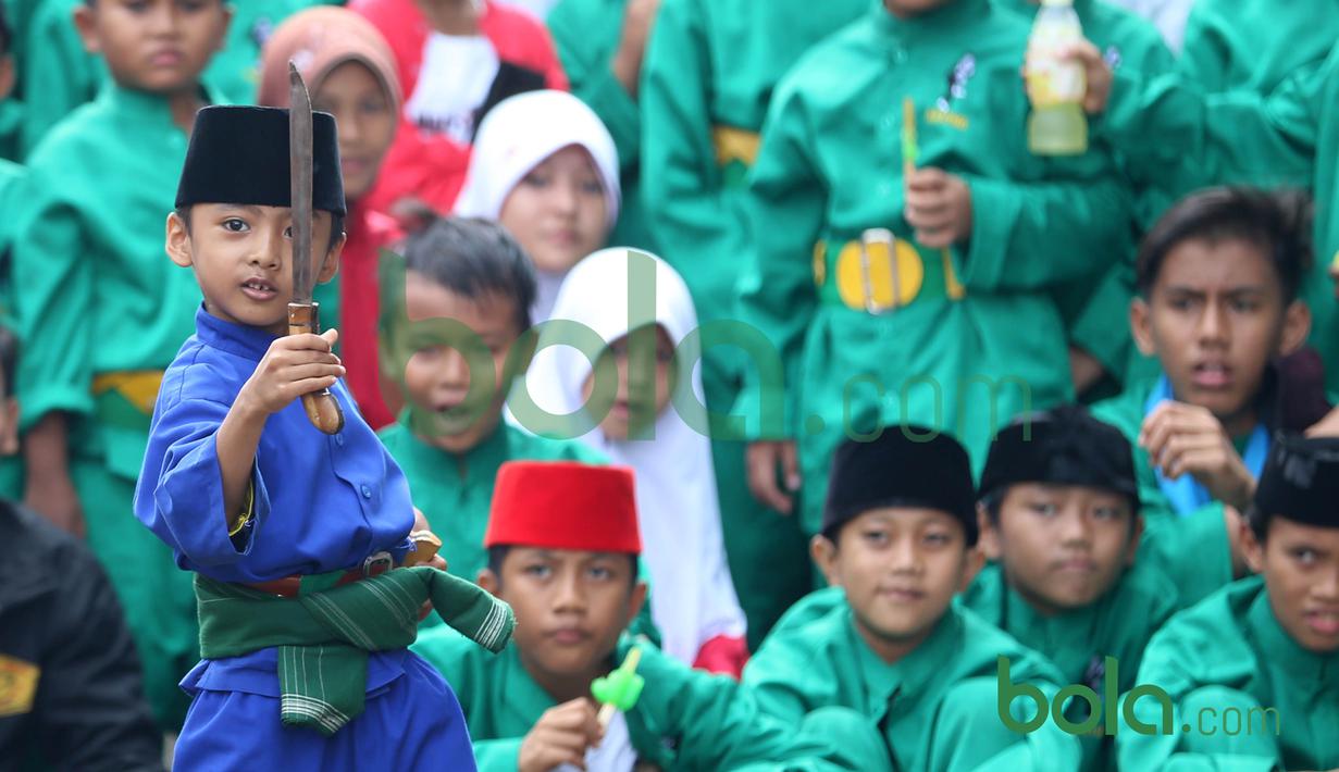 Seorang Bocah memperagakan gerakan Silat Betawi di Kawasan Senayan, Jakarta, Minggu (8/11/2015). Kegiatan ini merupakan  bagian dari Silahturahmi Main Pukul Betawi. (Bola.com/Nicklas Hanoatubun)