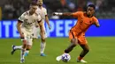 Penyerang timnas Belgia Leandro Trossard (kiri) berebut bola dengan bek Belanda Jurrien Timber pada matchday pertama Grup D Liga A UEFA Nations League 2022/2023 di Stadion Raja Baudouin, Sabtu (4/6/2022) dini hari WIB. Belanda sukses menghajar Belgia dengan skor telak 4-1. (JOHN THYS / AFP)