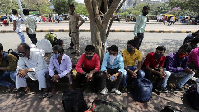 Pekerja migran dari negara bagian Bihar yang mengenakan masker wajah menunggu kereta di stasiun kereta Lokmanya Tilak di Mumbai, India, Rabu (7/4/2021). India mencapai puncak baru dengan 115.736 kasus COVID-19 dalam 24 jam. (AP Photo/Rafiq Maqbool)