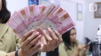 Pegawai menunjukkan mata uang rupiah di penukaran uang di Jakarta, Rabu (4/3/2020). Rupiah ditutup menguat 170 poin atau 1,19 persen menjadi Rp14.113 per dolar AS dibandingkan posisi hari sebelumnya Rp14.283 per dolar AS. (Liputan6.com/Angga Yuniar)