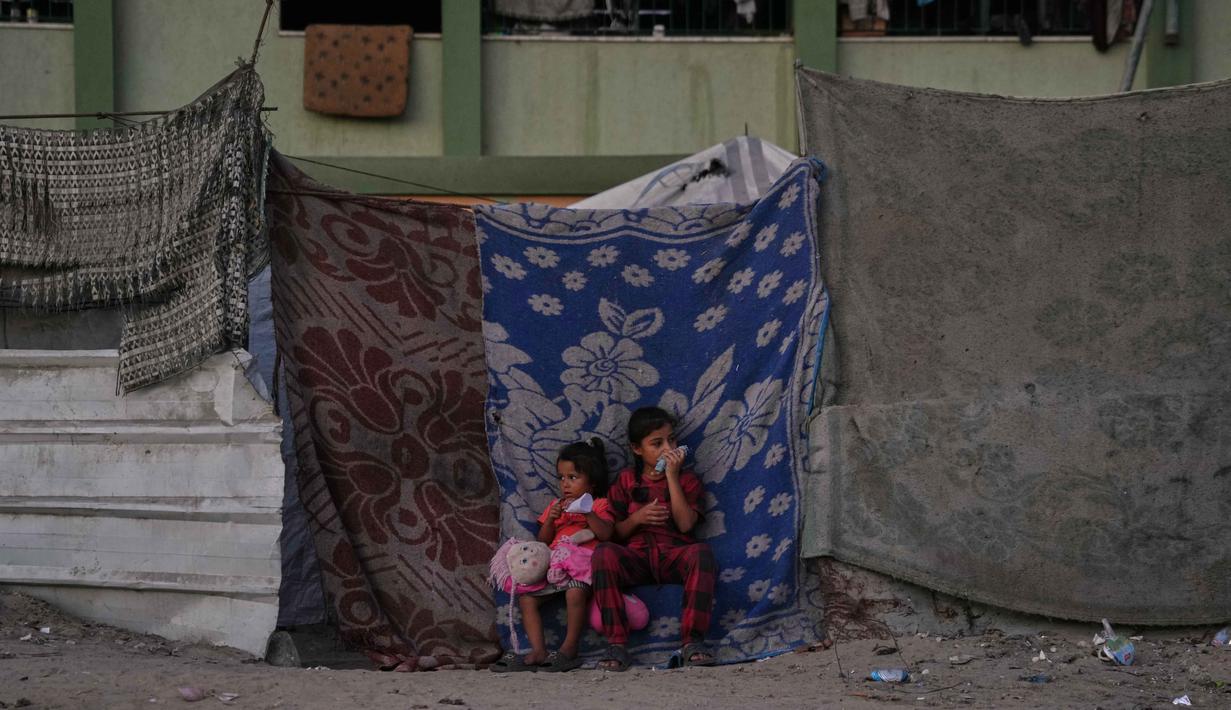 Gadis-gadis Palestina duduk di depan tenda keluarga mereka yang didirikan di sebuah area di Khan Younis, Jalur Gaza selatan, Jumat, 31 Oktober 2025. Organisasi bantuan, seperti yang didukung oleh Program Pangan Dunia (WFP), berupaya menyediakan makanan, namun menghadapi tantangan besar dalam distribusi dan pasokan yang tidak mencukupi target harian. (AP Photo/Abdel Kareem Hana)