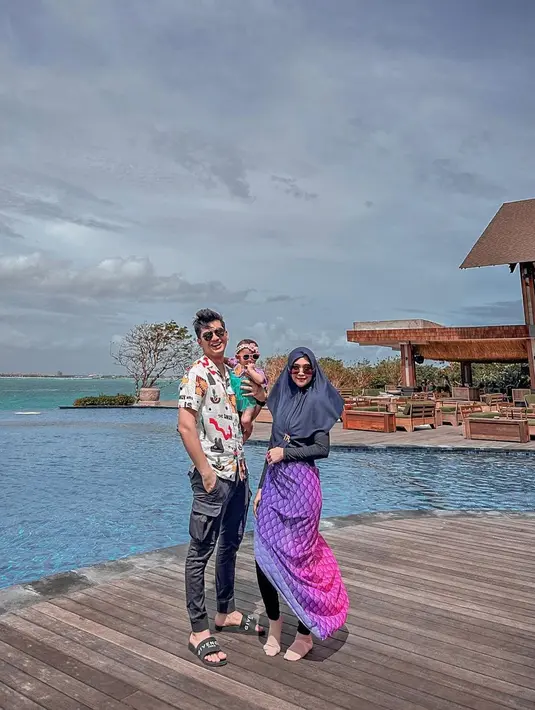 Dikenal dengan gaya mermaid-nya, Ria Ricis juga menambahkan kain sisik ikan warna pink yang diikat di pinggangnya. @riaricis1795.