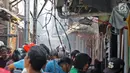 Sejumlah warga berusaha memadamkan api membakar pemukiman padat penduduk di kawasan Manggarai, Jakarta, Rabu (10/7/2019). Belum diketahui pasti penyebab api membakar pemukiman warga tersebut. (Liputan6.com/Herman Zakharia)
