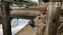 Sejumlah warga memancing ikan di kubangan yang berada di Jalan DI Panjaitan, Jatinegara, Jakarta, Selasa (16/6/2020). Meski telah dipagari, sejumlah warga tetap memancing ikan di lokasi yang merupakan saluran pembuangan tersebut. (Liputan6.com/Immanuel Antonius)
