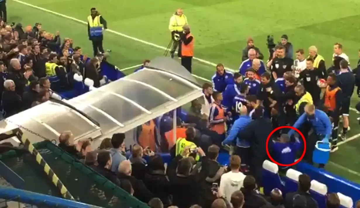 Guus Hiddink terlihat terjatuh akibat dorongan para pemain Chelsea dan Tottenham yang sedang ribut. Hiddink terjengkang ke belakang dari posisi cukup tinggi, dia terjerembab masuk ke 'dugout' kursi pemain pengganti. (Twitter/@Jonathankydd)