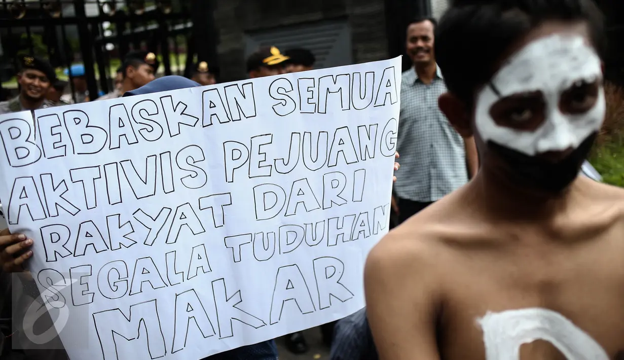 Sebuah poster berisi tuntutan dibawa oleh massa yang tergabung dalam Aksi Solidaritas Mahasiswa di depan Gedung Polda Metro Jaya, Jakarta, Jumat (9/12). Mereka menuntut agar para tersangka dugaan makar dibebaskan. (Liputan6.com/Faizal Fanani)
