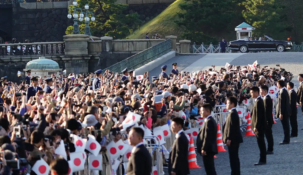 Ribuan warga menyaksikan parade Kaisar Naruhito dan Permaisuri Masako di Tokyo, Jepang, Minggu (10/11/2019). Warga datang sejak pagi agar mendapatkan tempat terbaik untuk menyaksikan parade tersebut. (AP Photo/Eugene Hoshiko)