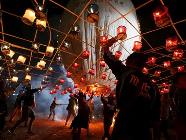 Warga menyalakan Lampion buatan tradisional sebelum melepaskannya ke langit selama festival tahunan Tazaungdaing di Taunggyi, Myanmar (19/11). (REUTERS/Soe Zeya Tun)