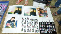 Salah satu pedagang yang menjual gantungan kunci dan poster bergambar Olga Syahputra di TPU Malaka, Jakarta, Selasa (31/3/2015). Empat hari pascakepergian komedian Olga, antusiasme masyarakat berkunjung ke makam masih tinggi. (Liputan6.com/Panji Diksana)