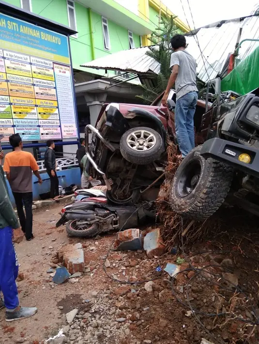 Warga membantu proses evakuasi saat truk tronton menabrak kendaraan di depan RSU Muhammadiyah Siti Aminah Bumiayu, Brebes, Jawa Tengah, Senin (10/12). Truk mengalami rem blong diduga setelah melintas di jalan menurun. (Liputan6.com/Fajar Eko Nugroho)