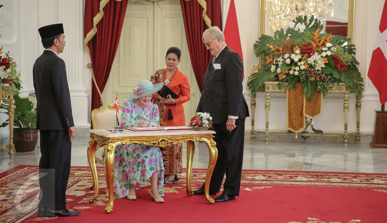 Ratu Denmark Margrethe II mengisi buku tamu disaksikan Presiden Jokowi (kiri) saat melakukan kunjungan kenegaraan di Istana Merdeka, Jakarta, Kamis (22/10). Pertemuan keduanya untuk mempererat hubungan kerja sama. (Liputan6.com/Faizal Fanani)