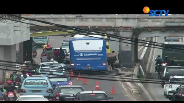 Bus transjakarta koridor 5 jurusan Kampung Melayu - Ancol Rabu (22/11) pagi menyangkut di bawah jempatan kereta api setelah menabrak palang.