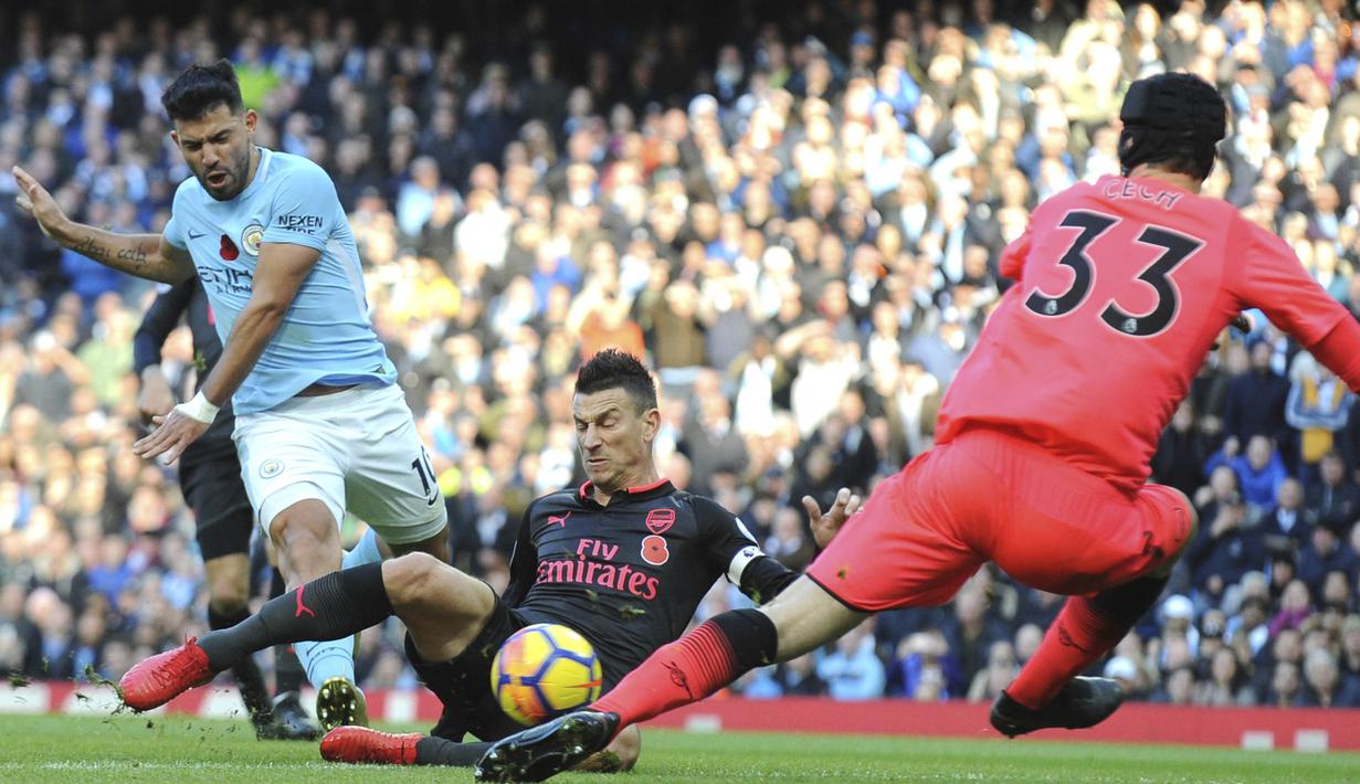 Striker Manchester City, Sergio Aguero, berusaha membobol gawang Arsenal yang dijaga Petr Cech pada laga Premier League di Stadion Ettihad, Manchester, Minggu (5/11/2017). City menang 3-1 atas Arsenal. (AP/Rui Vieira)