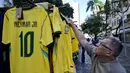 Seorang pria melihat kaus tim sepak bola nasional Brasil yang dipajang di pasar Saara, Rio de Janeiro, Brasil, pada Selasa 9 Juni 2026, menjelang turnamen Piala Dunia FIFA 2026. (Nelson ALMEIDA/AFP)
