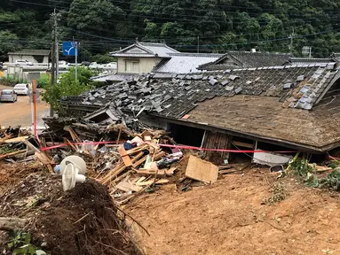 Pemandangan menunjukkan rumah yang roboh setelah tanah longsor yang disebabkan hujan lebat di Ashikita, Prefektur Kumamoto, Jepang, Minggu (5/7/2020). Banjir di wilayah Kumamoto ini telah menghancurkan ratusan rumah dan kendaraan serta membuat jembatan antar kota terputus. (STR/JIJI PRESS/AFP)