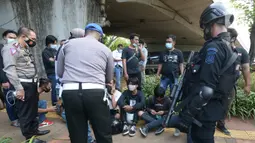 Polisi merazia pelajar yang sedang berkumpul di sekitar Gedung DPR/MPR, Jalan Gatot Subroto, Jakarta, Rabu (7/10/2020). Sejumlah akses jalan menuju lokasi dijaga menyusul adanya aksi demonstrasi kelompok buruh yang menolak UU Omnibus Law Cipta Kerja. (merdeka.com/Imam Buhori)