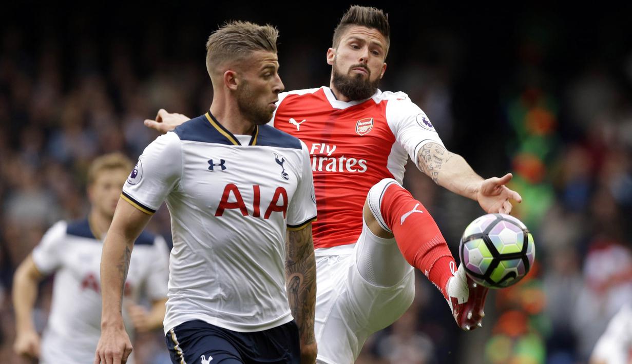 Striker Arsenal, Olivier Giroud, berusaha melewati bek Tottenham, Toby Alderweireld, pada laga Premier League di Stadion Emirates, London, Sabtu (18/11/2017). Arsenal menang 2-0 atas Tottenham. (AP/Alastair Grant)