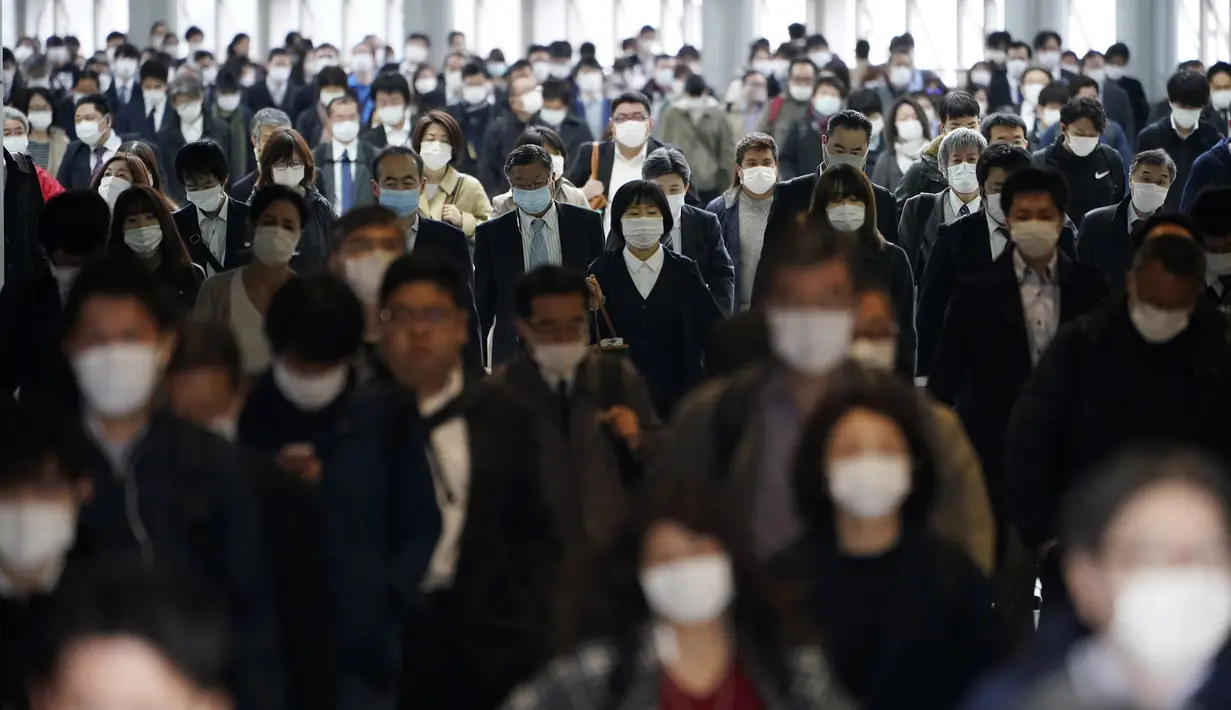 Lorong stasiun penuh dengan penumpang yang memakai masker di Tokyo, Jepang, 27 April 2020. Banyak warga Jepang yang masih pergi bekerja dengan menggunakan kereta walaupun ada risiko tertular virus corona COVID-19. (AP Photo/Eugene Hoshiko, File)