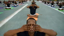 Personel Angkatan Laut India melakukan gaya yoga di atas kapal induk INS Viraat di Mumbai, India, (21/6). PM Narendra Modi mengatakan 21 Juni dirinya dan jutaan orang di seluruh dunia merayakan Hari Yoga Internasional. (AFP Photo/Punit Paranjpe)