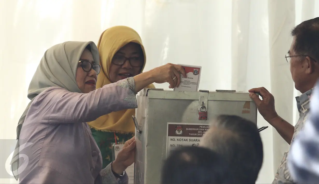 Istri Wapres Jusuf Kalla (JK), Mufidah Kalla, memasukkan surat suara usai mencoblos di TPS 03 Kelurahan Pulo, Jakarta Selatan, Rabu (19/4). Di TPS bernuansa Betawi itu, JK dan istri memberikan suaranya pada Pilkada DKI 2017. (Liputan6.com/Herman Zakharia)