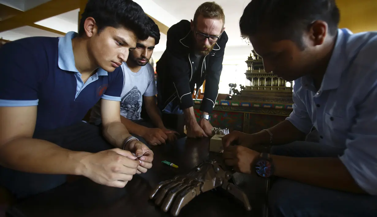 Tim dari Disaster Hack menyiapkan tangan palsu 3D yang akan diberikan kepada penderita kusta di Kathmandu (14/7). Tangan palsu ini dibuat dengan dari mesin cetak 3D. (AFP Photo/Gopen Rai)