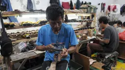 Perajin alas kaki menyelesaikan pembuatan sandal di kawasan Bojongsari, Depok, Jawa Barat, Selasa (22/2/2022). Sandal-sandal tersebut dijual ke Jakarta serta kota-kota di Pulau Sulawesi dan Pulau Bali. (merdeka.com/Arie Basuki)