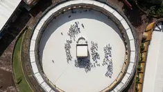 Sebuah gambar udara menunjukkan calon jemaah haji Indonesia berlatih ritual tawaf mengelilingi replika Ka'bah, selama sesi pelatihan di Pusat Pelatihan Manasik Al Mahmudah (AMTC) di Tangerang Selatan pada 5 April 2026. Presiden Prabowo Subianto memutuskan untuk menurunkan biaya haji 2026 sebesar Rp 2 juta. (Foto oleh AFP)