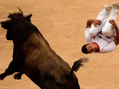 Seorang peserta melompat melewati seekor banteng dalam Festival San Fermin di Pamplona, Spanyol, (11/7/2015). (AP Photo/Andres Kudacki)