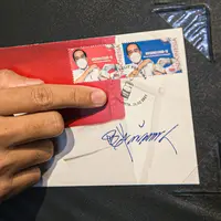 Petugas menunjukkan perangko seri vaksinasi COVID-19 di Kantor Filateli, Jakarta, Jumat (26/2/2021). Kementerian Komunikasi dan Informatika meluncurkan perangko seri vaksinasi COVID-19 bergambar Jokowi berkemeja putih dan memakai masker sedang disuntik vaksin. (Liputan6.com/Faizal Fanani)