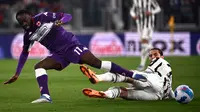 Pemain Fiorentina Jonathan Ikone (kiri) berebut bola dengan pemain Juventus Adrien Rabiot pada pertandingan leg kedua semifinal Coppa Italia di Stadion Juventus, Turin, Italia, 20 April 2022. Juventus menang 2-0. (Marco BERTORELLO/AFP)