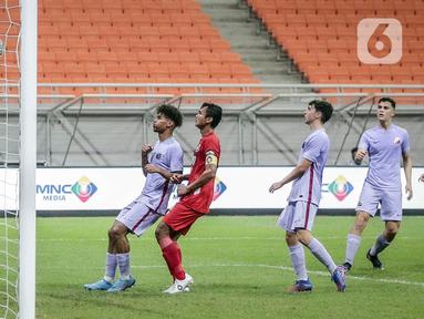 Kiper Indonesia All Star U-20 Ahludz Dzikri Fikri (kiri) menangkap bola saat bermain melawan FC Barcelona U-18 pada pertandingan International Youth Championship 2021 di Jakarta International Stadium, Jakarta, Rabu (13/4/2022). Pertandingan berakhir imbang 0-0. (Liputan6.com/Faizal Fanani)