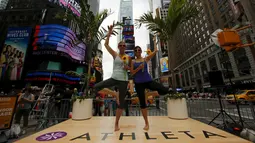 Dua wanita melakukan gerakan yoga di tengah jalan saat perayaan Summer Solstice di Hari Yoga Internasional di Times Square, New York, Minggu (21/6/2015). (REUTERS/Eduardo Munoz)