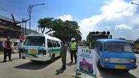 Polantas Polres Bogor mengatur lalu lintas yang melintasi Pos Pengawasan Larangan Mudik di Cigombong, Bogor, Rabu (29/4/2020). Polres Bogor melakukan penyekatan  di perbatasan dengan Cianjur yaitu Pos Rindu Alam dan perbatasan Sukabumi di Pos Cigombong. (merdeka.com/Arie Basuki)