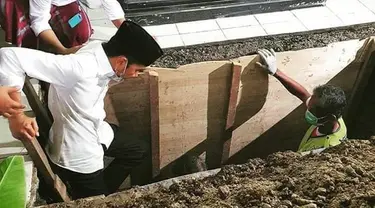 Presiden Joko Widodo atau Jokowi saat turun ke liang lahat untuk memakamkan jenazah ibundanya Sudjiatmi Notomihardjo di pemakaman keluarga di Mundu, Kabupaten Karanganyar, Jawa Tengah, Kamis (26/3/2020). Sujiatmi Notomiharjo wafat pada Rabu 25 Maret 2020 pukul 16.45 WIB. (dok.istimewa)