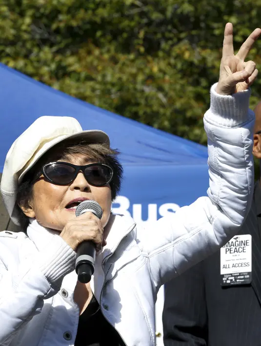 Yoko Ono menunjukkan tanda perdamaian saat ia bernyanyi bersama ribuan orang yang berkumpul untuk membentuk simbol perdamaian raksasa di New York Central Park , Selasa (6/10). Kegiatan itu menandai ulang tahun John Lennon ke-75.(REUTERS/Mike Segar)